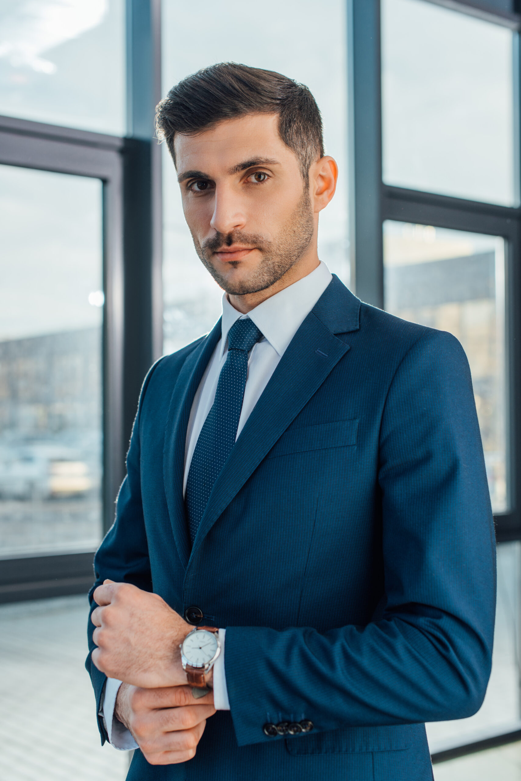 handsome professional businessman in suit posing in modern office
